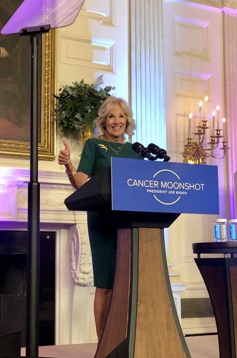 First Lady Jill Biden, Ed.D. stands at a podium giving prepared remarks at a Cancer Moonshot event in the White House