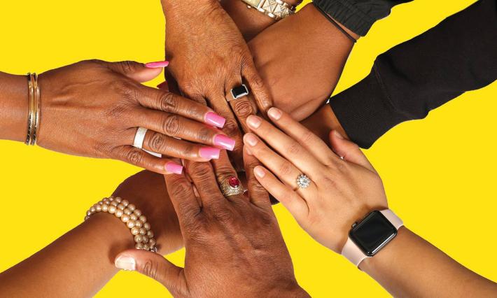 A group of black peoples' hands stacked on top of each other