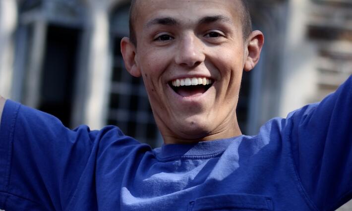 Bobby Menges smiling with his arms raised