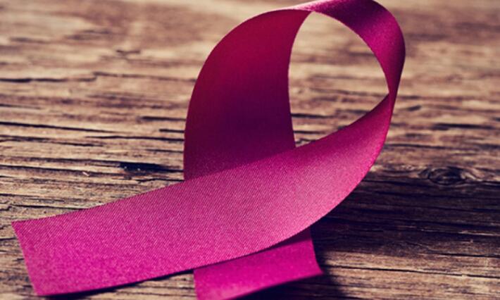 pink breast cancer ribbon with a woodgrain background