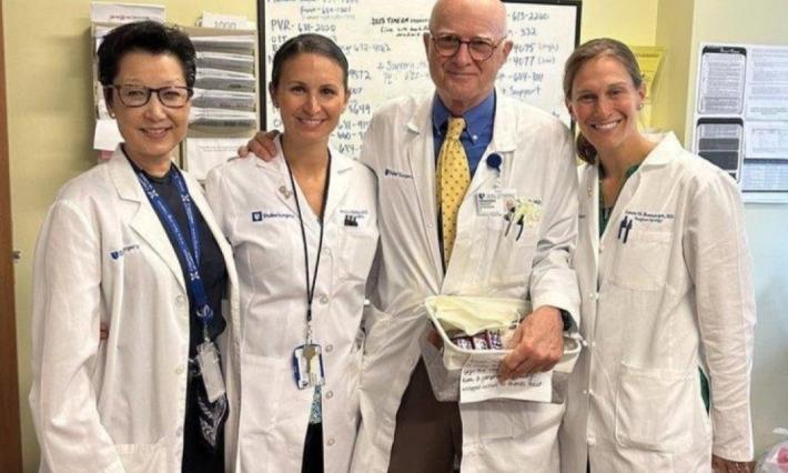 Shelly Hwang, Jennifer Plichta, Gregory Georgiade, and Laura Rosenberger — all in white lab coats — pose in a clinic room 