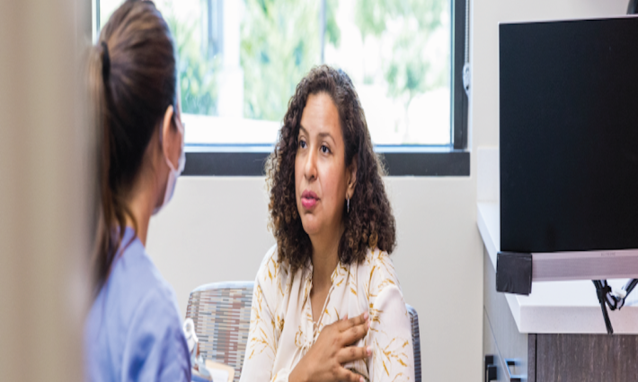 Female patient talks to provider in medical office