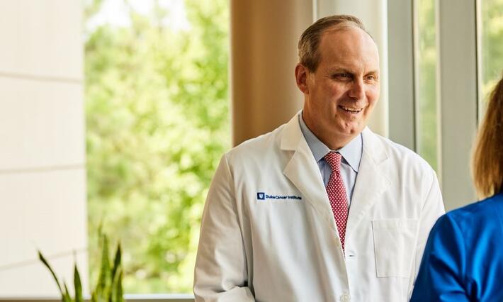 Peter Allen speaking with colleague