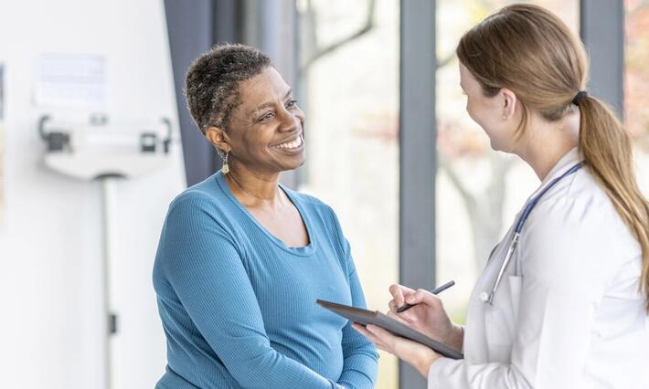 A doctor speaks with a patient in a clinic room