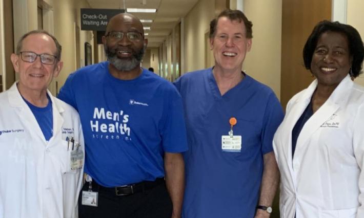 Four medical professionals smiling inside hospital