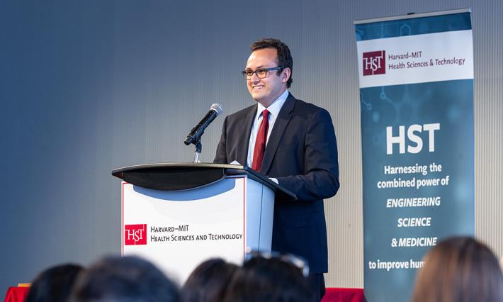 Kameron Kooshesh, MD, at a lectern in front of a Harvard Health Sciences sign