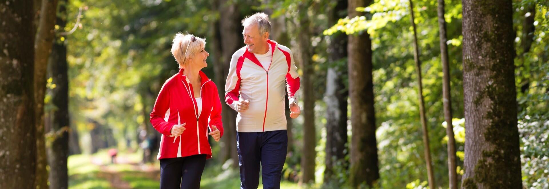 Older couple running in the woods