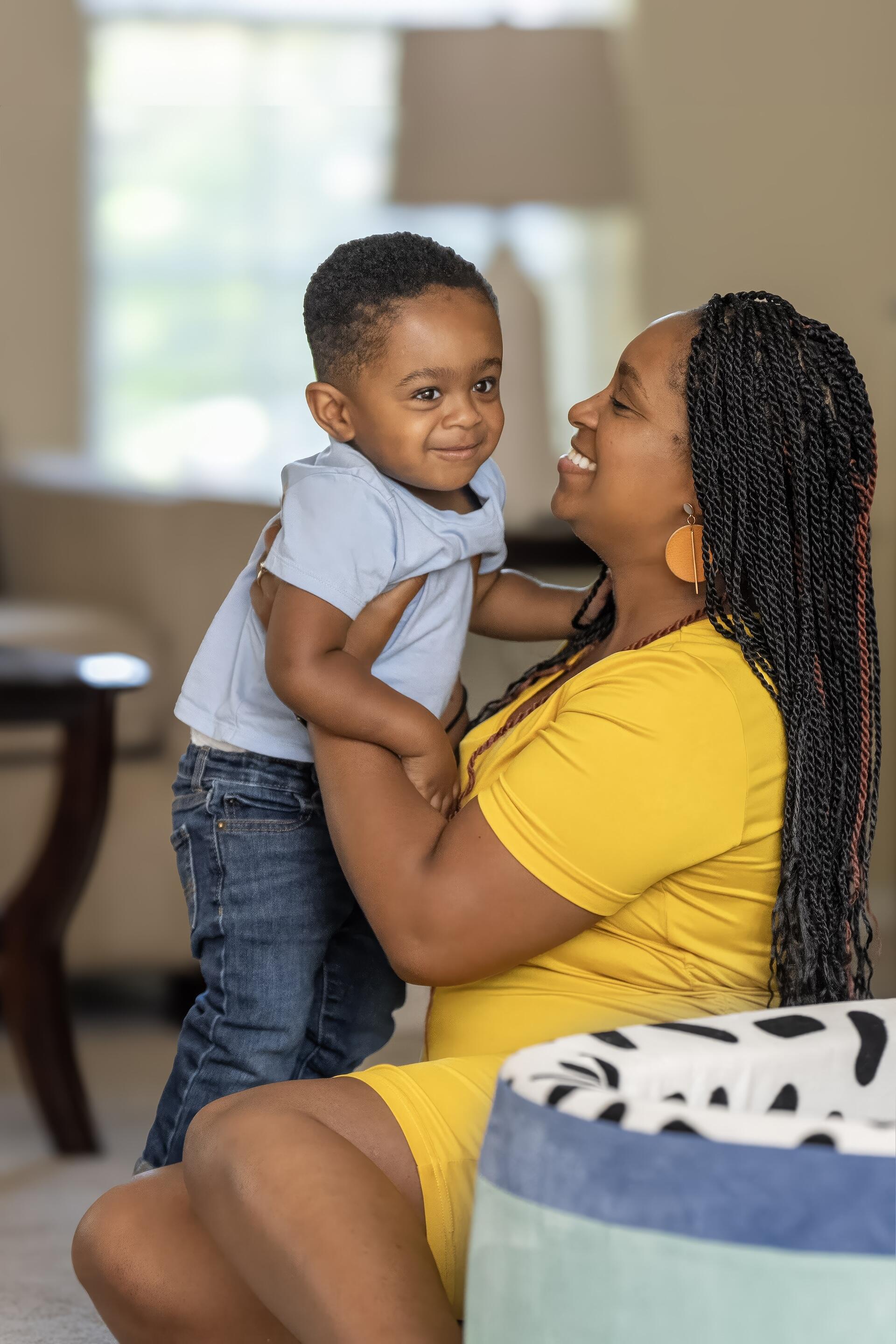  Portrait of Arlene Brown holding her toddler son, both smiling at the camera.