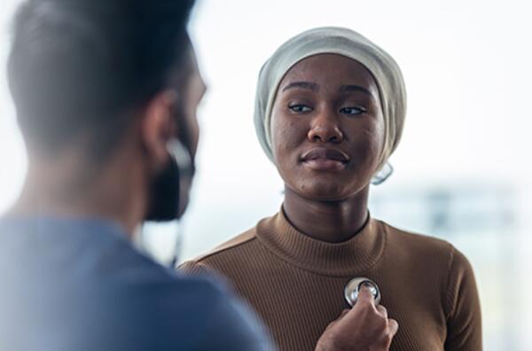 Man places stethescope on woman's heart