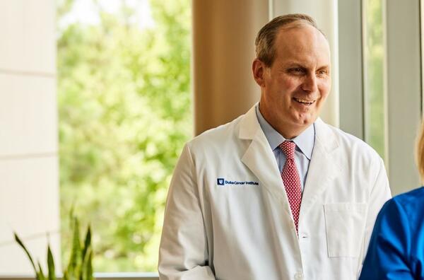 Peter Allen speaking with colleague