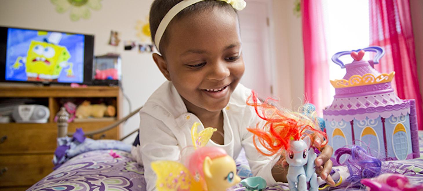 Photo of young cancer survivor Layla Smith playing with her toys