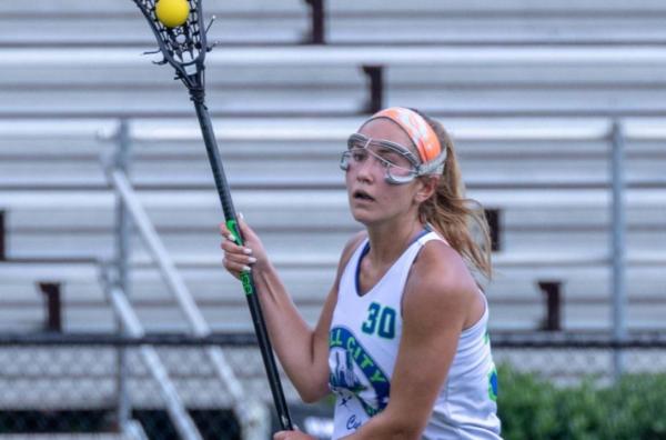 A young woman plays lacrosse