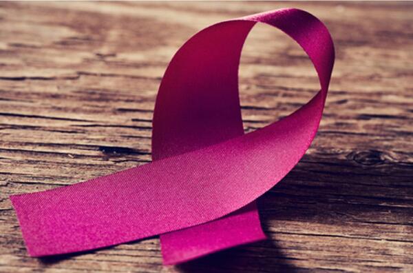pink breast cancer ribbon with a woodgrain background