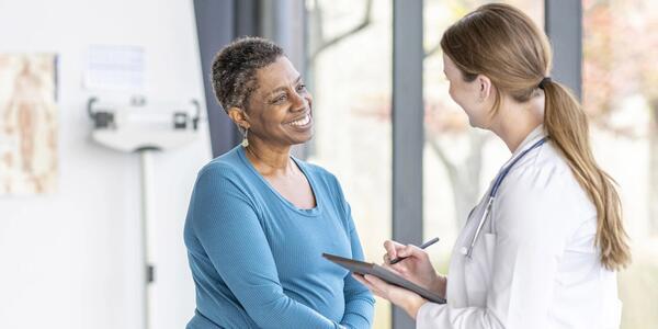 A doctor speaks with a patient in a clinic room