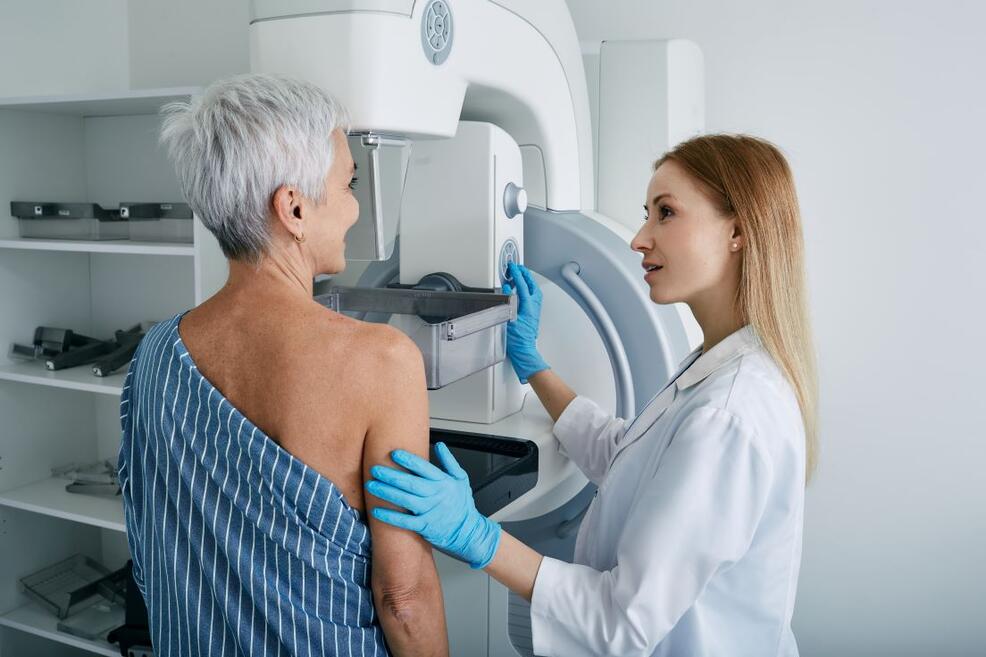 Doctor administering mammogram to a patient