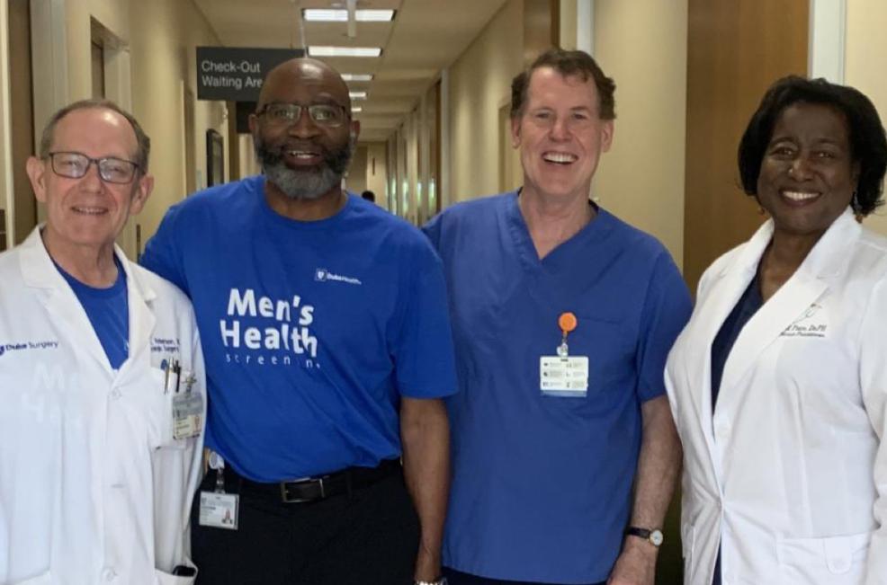 Four medical professionals smiling inside hospital
