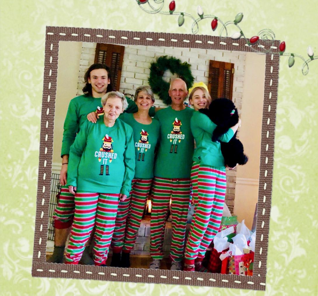 Kathy Jennings' family--including her two adult children, her husband, and her mother--stand in matching Christmas pajamas. Their pajama shirts have a nutcracker on the front and say "crushed it."