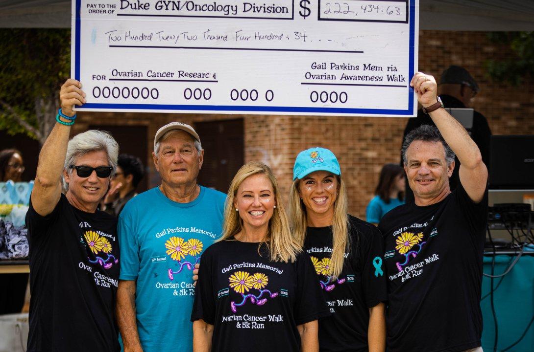 Founder of the Gail Parkins Memorial Ovarian Cancer Walk & 5K Run Melanie Bacheler (center) with her brother Wayne, dad Mike, niece Emily and husband Tim present the Duke GynOnc Division with check for funds raised at 2021 event.