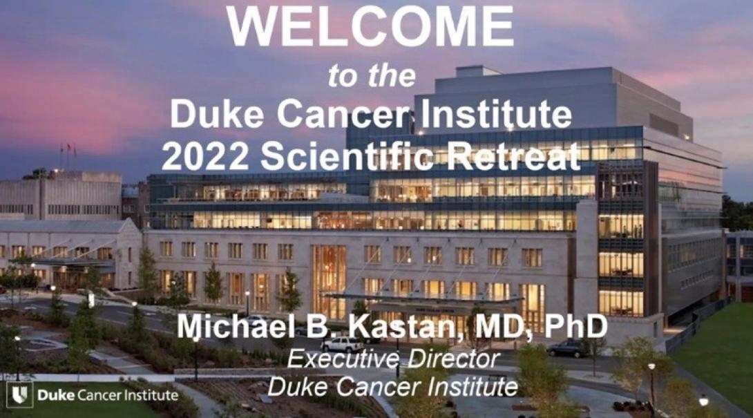 large building with lights on at sunset with overlaid message "Welcome to the Duke Cancer Institute 2022 Scientific Retreat: Michael B. Kaftan, MD, PhD, Executive Director, Duke Cancer Institute"