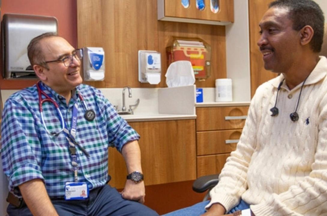 Two men talking in a clinic room 