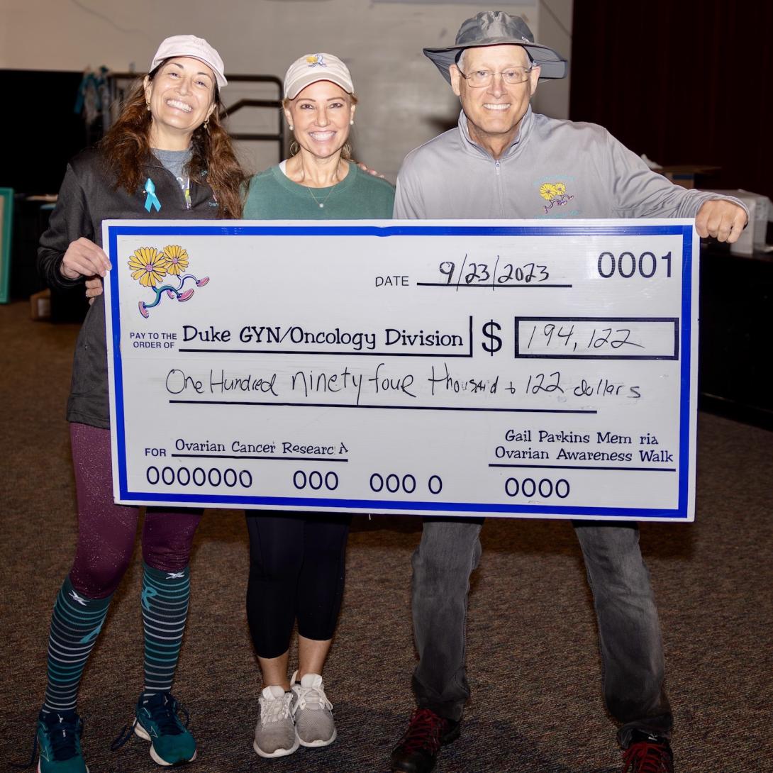 three smiling people hold a giant poster-size check in the amount of $194,192 made out to Duke Gyn/Onc Division